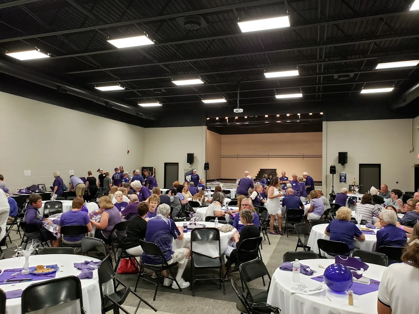 A full room of guests at round tables during a gathering at SandHills Event Center